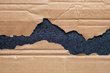 Torn cardboard box with black protective polyurethane foam
