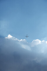 白い雲と飛行機のシルエット　青空　旅　進む　コントラスト　