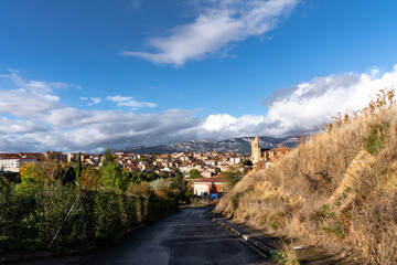 Klein Landstraße mit Ausblick auf den keleinen Ort Elciego im Baskenland in Spanien