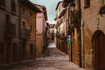 Fototapeta na wymiar Enge Straße Einbahnstraße mit Verkehrsschild geradeaus in der Kleinstadt Elciego im Baskenland in Spanien