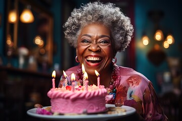 Happy laughing African grandma with little birthday cake with candles - obrazy, fototapety, plakaty