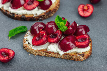 Fresh bread sandwiches with sweet cherry, cream cheese and mint leaves. Morning breakfast concept