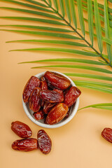 Ripe dates, a traditional Ramadan Kareem concept snack for Iftar or Suhoor meal on a light orange