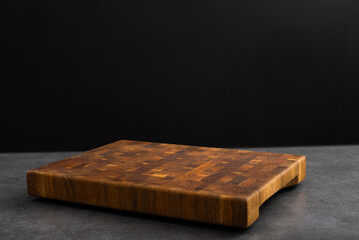 Wooden board for cutting on a black background.