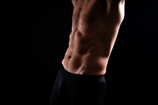 Handsome bodybuldier man posing showing muscle, shirtless torso showing pectorals and sixpack