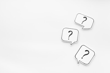 Question marks on paper speech bubbles, top view. Ask and answer concept