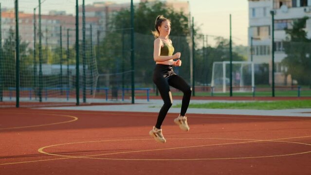 Athletic woman running in place and training at the stadium.