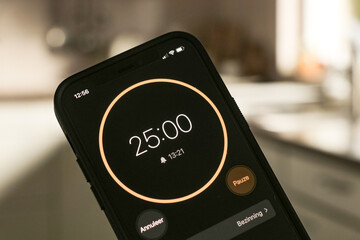 A phone with a black and white 25-minute timer to study with the pomodoro method on a blurry background. Perfect for students planning their time studying, doing homework, being productive.	 - obrazy, fototapety, plakaty