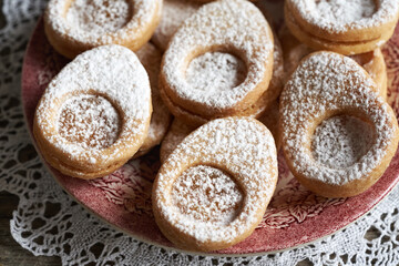 Linzer cookies in the shape of Easter eggs on a red plate, closeup