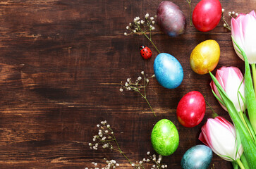 Easter composition with eggs and flowers on a wooden background