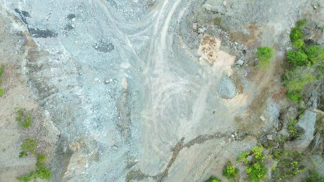 Overhead view of a quarry site in Puerto Princesa shows pale gravel roads stone piles exposed earth and sparse trees around the work area