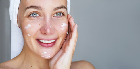 Skin care routine. Young beautiful woman is  posing with a smears or a facial care brauty  product...