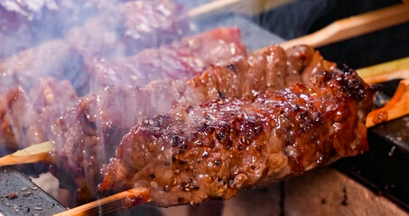 Beef Shish Kebab, stripes sliced meat cooking with flame. Homemade shashlik cooking or restaurant,...