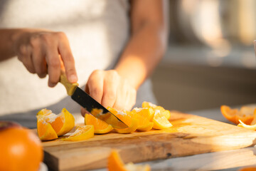 Close up shot of woman slicing oranges of making juice at morning in kitchen - concept of healthy lifestyle, nutrition and refreshing. - obrazy, fototapety, plakaty