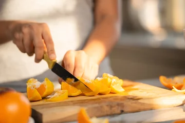 Foto op Plexiglas Close up shot of woman slicing oranges of making juice at morning in kitchen - concept of healthy lifestyle, nutrition and refreshing. © WESTOCK