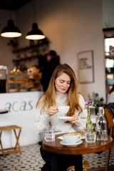 Happy woman drinking coffee in a cafe