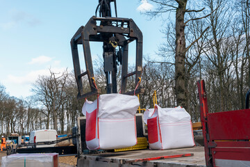 Dropside flatbed HIAB crane lorry with brick grab attachment deliver materials on construction site...