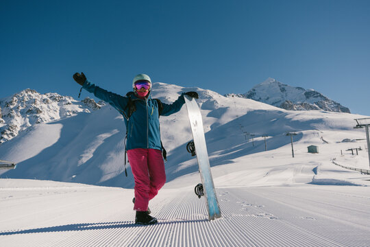 Female snowboarder on Snow trail from ratrak preparation, freshly groomed ski slope in high mountains ski resort