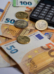 Euro banknotes, calculator and coins on the table