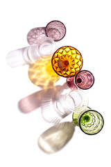 Top view of different color wine glasses with sun shadow and glare on a white background. Flat lay, copy space