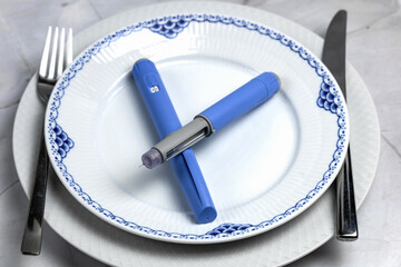 Ozempic Insulin injection pen or insulin cartridge pen for diabetics on a white plate.
