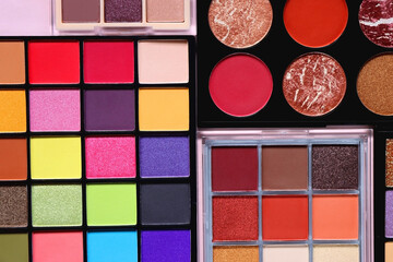 Various colorful eyeshadow palettes on bright pink background. Flat lay.