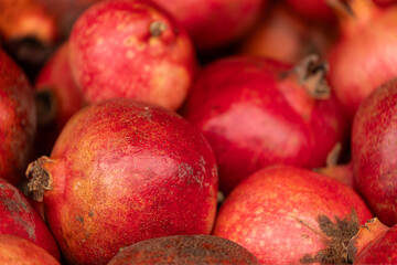 Close-up of bright fruits for background, texture. Red ripe pomegranates on display.