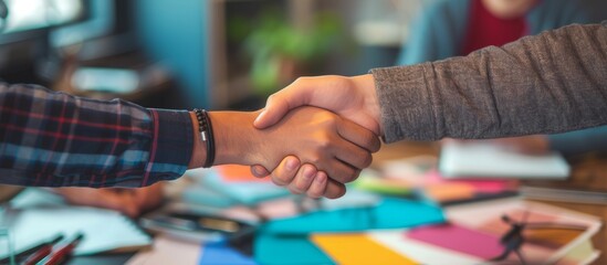 Collaborative workspace with colorful design elements and handshakes reflecting teamwork and creativity in interior and textile designing, coloristics, and product branding.