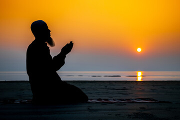 Asian Muslim bearded man praying to god on sunset background. Silhouette of an old age Muslim praying during sunset.