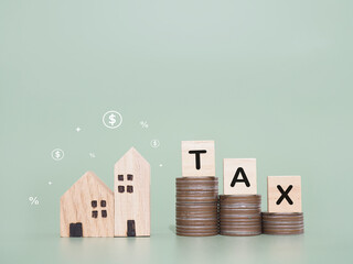 Miniature house, Wooden blocks with the word TAX and stack of coins. The concept of payment tax for house, Property investment, House mortgage, Real estate.