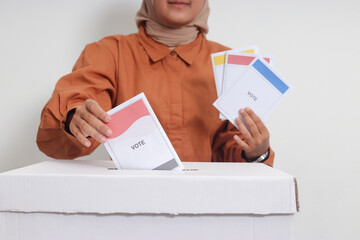 Close up of Asian hijab woman inserting and putting the voting paper into the ballot box. General...