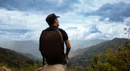 Una hombre turista con una mochila contemplando el asombroso paisaje de los Andes Peruanos con los brazos abiertos, concepto de turismo - obrazy, fototapety, plakaty