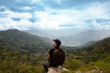 Foto op Canvas Una hombre turista con una mochila contemplando el asombroso paisaje de los Andes Peruanos con los brazos abiertos, concepto de turismo © Yoel Garay
