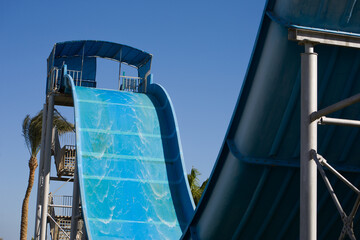 Water slide with a sharp descent in an outdoor aquapark. Extreme free fall on a water slide on...