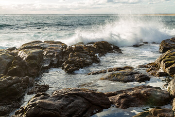 Waves splash against a rocky shore.