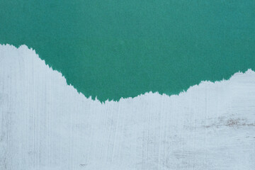 Texture of a piece of green paper on a gray shabby  wall