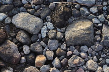 Large stones of different shapes on the riverbank close-up. there are a lot of small stones nearby.