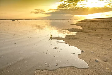 Selbstklebende Fototapeten Ondergaande zon met reflectie van de wolken over de Oosterschelde in Nederland. Het zeewater stroomt tijdens het opkomende getijde over de schorren. © ArieStormFotografie