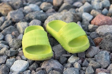 Pair of green sandals on the rocks
