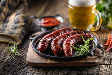 Sausages fried with spices bbq sauce draft beer and herbs - Close up