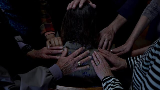 A group of Christians praying for a woman in need
