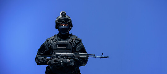 Soldier in black uniforms with weapon gun in studio. Banner Military army concept