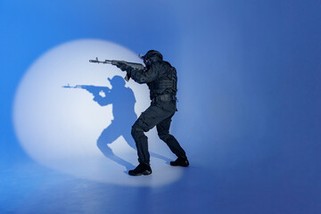 Soldier in black uniforms with weapon in studio, man full length photo. Concept Military warrior army tactical force to fight crime in city