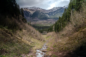 Obraz premium Beautiful mountain landscape. Clouds in the sky. Green grass. Snow on mountain peaks.
