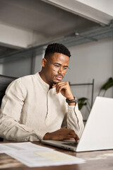 Busy professional African business man company employee, young male businessman looking at computer...