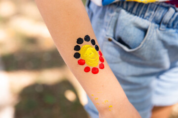 Aboriginal flag style artwork on a child's arm
