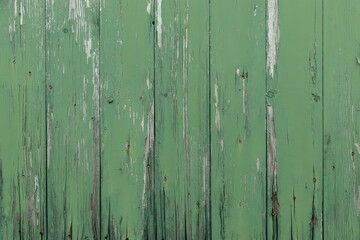 Fototapeta na wymiar Background texture of a old wheatered green plank fence with cracked paint