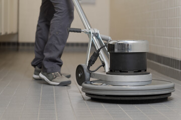 close-up of a buffer machine cleaning a ceramic floor