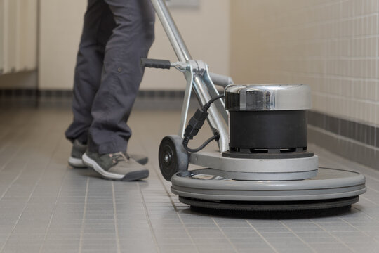 close-up of a buffer machine cleaning a ceramic floor