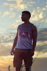 Young Brazilian Latino man looking at the horizon on a sunset breathing fresh air